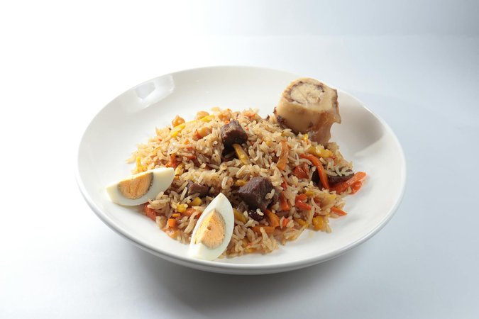 Jollof rice ghanese tradizionale con pollo e salsa di pomodoro